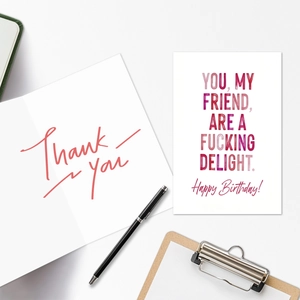 Flat lay of colorful birthday and thank you greeting cards with an elegant black pen