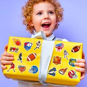 Lachende jongen met een gele geschenkdoos versierd met diverse Amerikaanse voetbalstickers