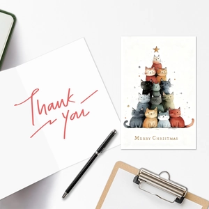 Detailed flat lay of cat Christmas tree cards and thank you note on a white desk
