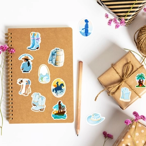 Detailed view of salt wind cowgirl stickers with blue denim patterns on a notebook