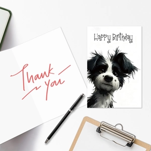 Detail of dog birthday card and thank you note with black pen on minimalist white desk