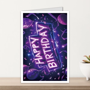 Neon style Happy Birthday card with purple balloon graphics on a wooden desk setup