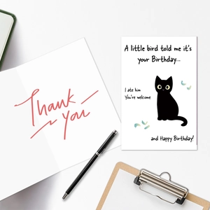 Flat lay of humorous black cat birthday cards and thank you notes with stationery props
