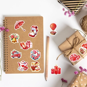 Close-up of romantic red graffiti stickers on a kraft notebook and gift box with dried flowers