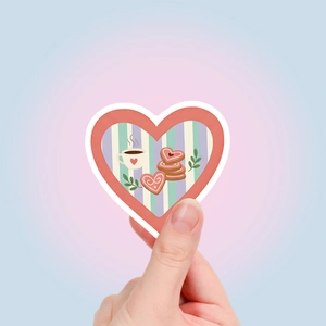 Detailopname van hartstickers met koffie en koekjes in de hand voor de schaal