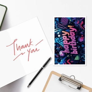 Detail of neon Happy Birthday and Thank You greeting card set on a white desk workspace