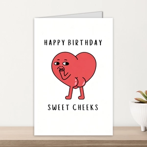 Detail of funny Happy Birthday card with red heart character on a wooden shelf