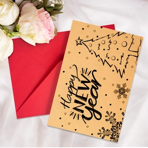 Close-up of yellow kraft Happy New Year card with red envelope on white satin fabric