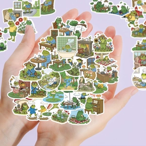 Close-up of hands holding assorted waterproof cartoon frog stickers for decoration