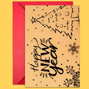 Macro shot of a New Year card with Christmas tree art and a festive red envelope