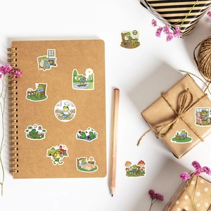 Cute cartoon frog stickers applied on a kraft paper notebook and a gift box decoration