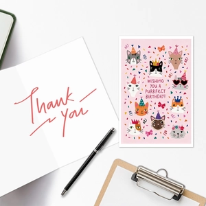 Détail de la carte d'anniversaire chat rose et carte de remerciement sur le bureau
