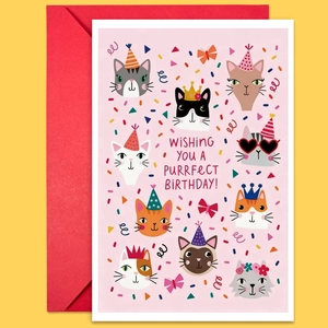 Gros plan d'une carte d'anniversaire chat rose avec enveloppe rouge sur fond jaune
