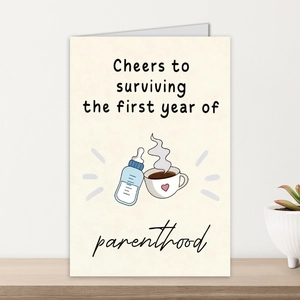 Close-up of greeting card with parenthood celebration text and coffee cup illustrations