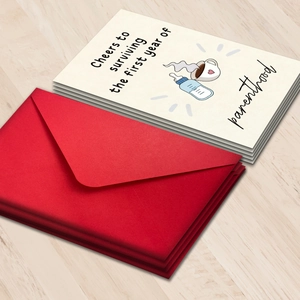 Cheers to parenthood greeting cards with red envelopes on warm wooden surface