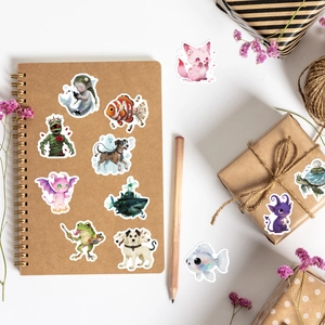 Adesivi per cartoni animati fantasy creativi disposti su un taccuino con fiori secchi