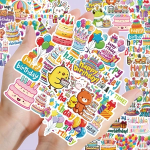 Close-up of hands holding colorful cartoon happy birthday stickers with cake and balloons