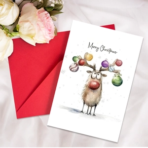 Detailed view of watercolor reindeer Christmas card with a red envelope on white fabric