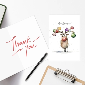 Detailed view of watercolor reindeer Christmas card and red Thank You note with a pen