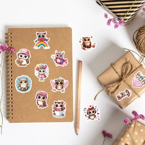 Cute pink owl stickers applied on a gift box and craft paper notebook for decoration