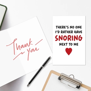 Close-up of engagement greeting cards with humorous snoring text and thank you note