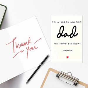 Detailed view of birthday cards for dad with 'Thank you' note and a black pen on a clipboard