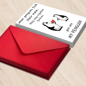 Cartoon penguin illustration Valentine's Day cards with red envelopes on wood background