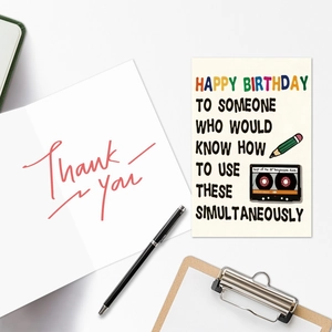 Detail of vintage 80s rock theme birthday card with envelope on creative desk setup