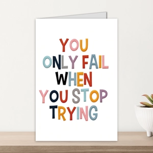 Close-up of inspirational card with colorful 3D letters on a light wooden shelf