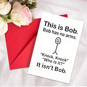 Close-up of humor greeting card with minimalist stick figure and red envelope on white silk