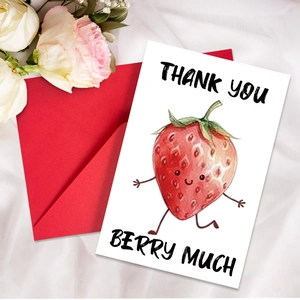 Detail of strawberry thank you card with red envelope on white textured fabric background