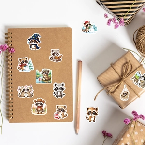 Flat lay of cute raccoon cartoon stickers decorating a kraft notebook and gift box