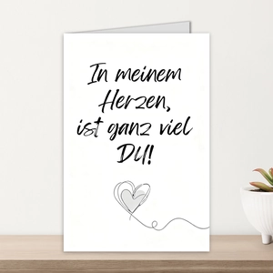 Detailansicht der weißen Grußkarte mit deutschem Text auf einem hellen Holztisch