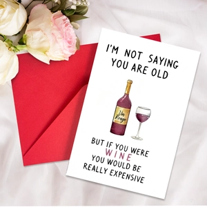 Flat lay of a funny birthday card with red wine illustration and matching red envelope
