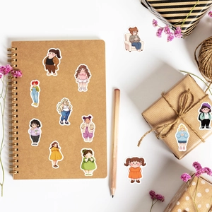 Flat lay van schattige ronde meisjesstickers die een notitieboek en doos versieren