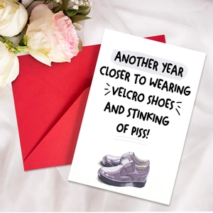Funny birthday card with red envelope featuring velcro shoes humor on silk background