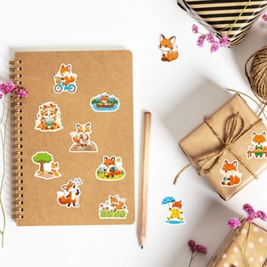 Detalle de lindas pegatinas de zorro aplicadas en cuadernos y cajas de regalo decorativas