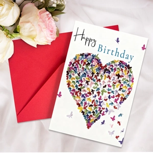 Close-up of heart card with colorful butterflies and a vibrant red envelope