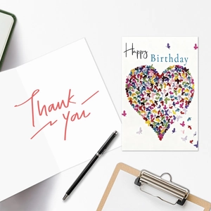 Flat lay of Happy Birthday heart butterfly card and Thank You card with stationery