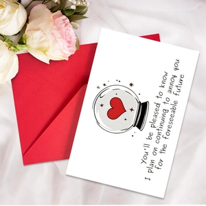 Detail shot of a white funny greeting card with a heart crystal ball and a red envelope