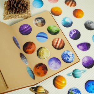 Macro detail of PET solar system planet stickers on a vintage kraft paper notebook