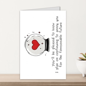 Close-up of minimalist white greeting card with hand-drawn crystal ball and red heart