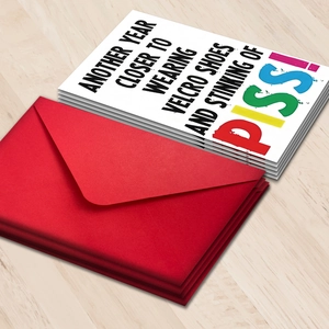 Funny humor birthday card set with red envelope and bold typography on wooden background