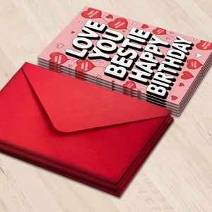 Set di biglietti d'auguri rosa con testo Love You Bestie e buste rosse su legno