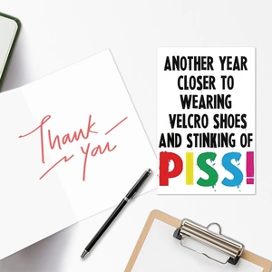 Close-up of minimalist paper birthday card set with handwritten text on wooden clipboard