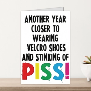 Funny greeting card on wooden table featuring bold text and minimalist humorous design