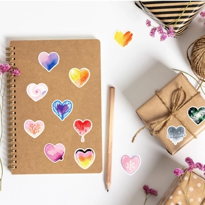 Flat lay of artistic watercolor heart stickers with celestial and gradient patterns