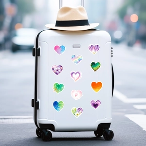 Close-up of artistic watercolor heart stickers applied to a white suitcase for decoration