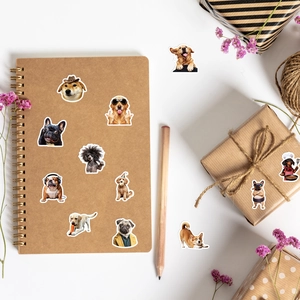 Flat lay of cute dog stickers with personified outfits on a notebook and gift box