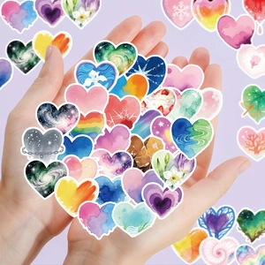 Detail showing hand holding watercolor heart-shaped stickers for phone case decoration